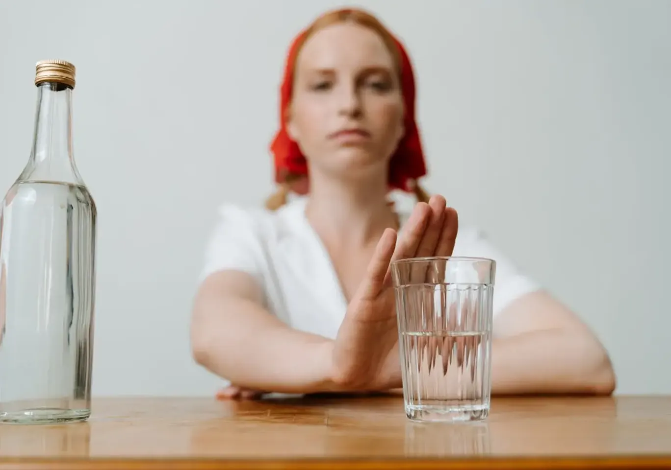 Leczenie alkoholizmu Przemyśl: kobieta odsuwa butelkę i sięga po wodę